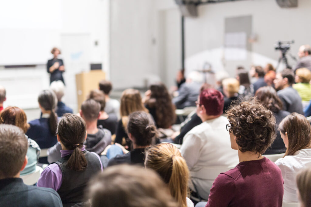 A group of students attending a university research presentation