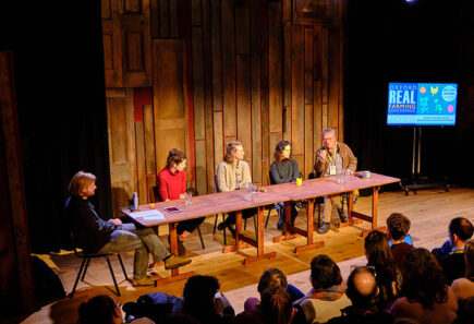 Panel at oxford real farming conference, sat at a warm wooden table, discussing the role of plant-based meat in the transition away from industrial animal farming