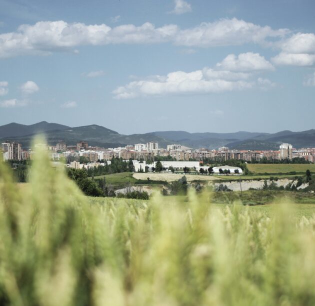 An arable farm in Pamplona, Spain, with a town in the background. Photo by Damien Dufour via Unsplash.